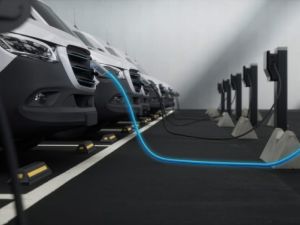 Fleet of generic electric EV delivery vans charging on charging stations